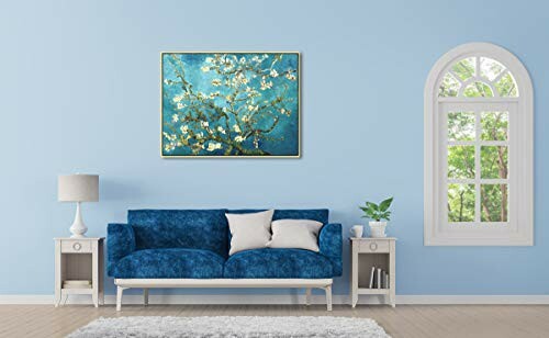 Salon avec canapé bleu et tableau floral.