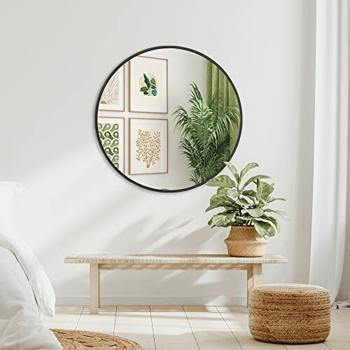 Miroir rond sur le mur avec plante en pot et tabouret en osier.